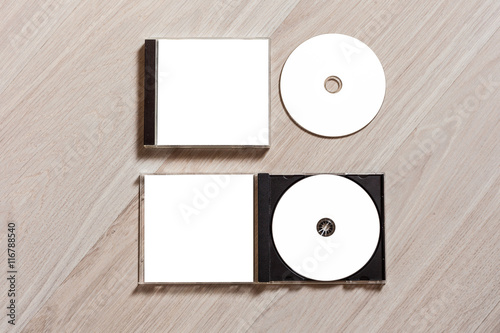 Closed compact disc template with plastic box case with white isolated blank for branding design and open box with booklet. CD jewel case mock up with clean free space for on wooden table. Top view