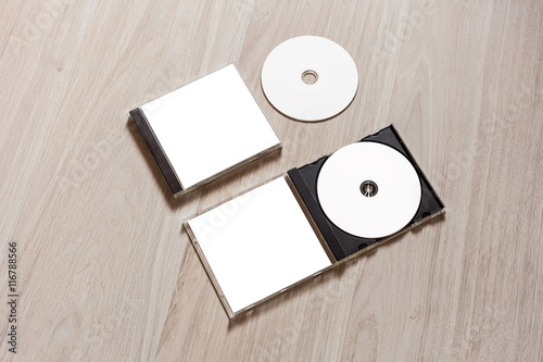 Closed compact disc template with plastic box case with white isolated blank for branding design and open box with booklet. CD jewel mock up with clean free space on wooden table. Perspective view