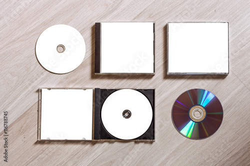 Full set compact disc template with plastic box case with white isolated blank for branding design and open box with booklet and back side. CD jewel case mock up with free space on wooden table.