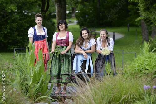 Germany, Bavaria, four smiling women wearing dirndls photo