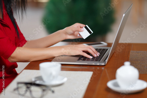 Hands holding credit card and using laptop