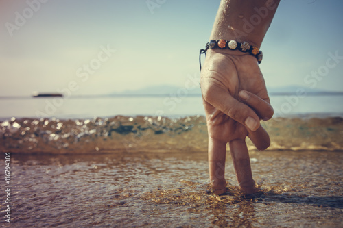 conceptual pictures - hand in the form of man on the beach at sunrise