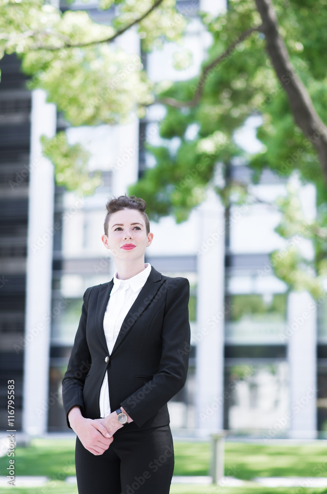 Modern business woman standing and loooking out Modern business woman standing and loooking out