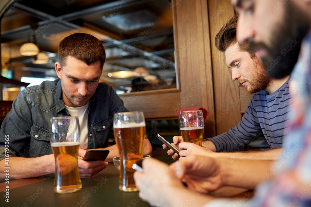 men with smartphones drinking beer at bar or pub men with smartphones drinking beer at bar or pub