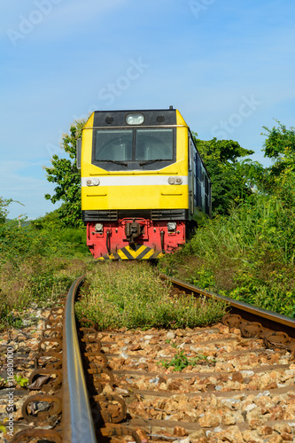 Train on railway track with and green grass and blue sky backgro