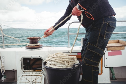 Fisherman tying rope on bollard photo