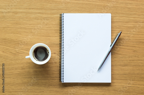 Scrivania d'ufficio con blocco note, penna e tazza di caffè