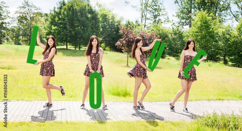Fototapeta premium young smiling girls holding letters with the word love