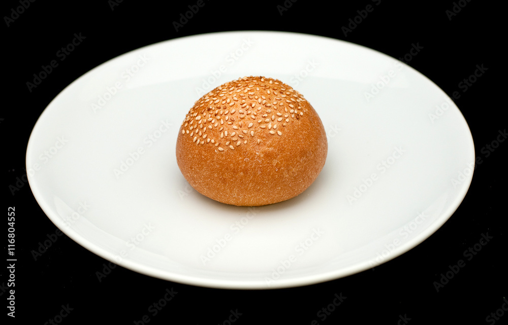Sandwich bun with sesame on white plate 
