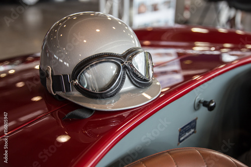 Helmet and glasses on a luxury convertible sports car.