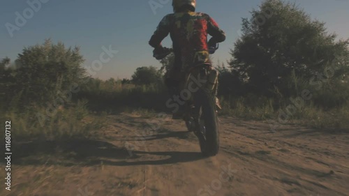 Off-road motorbike goes on the road in a field