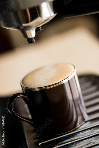 espresso machine making coffee and pouring in a brown cup