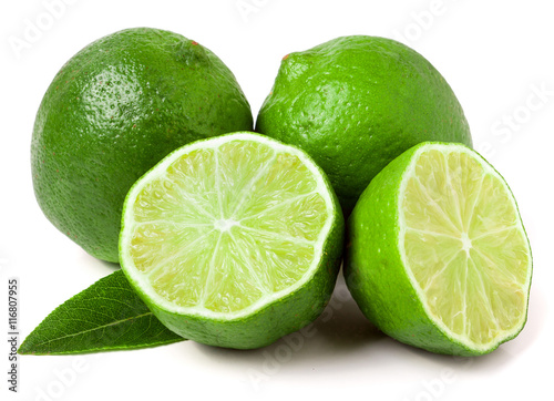 two limes with halves and leaf isolated on white background