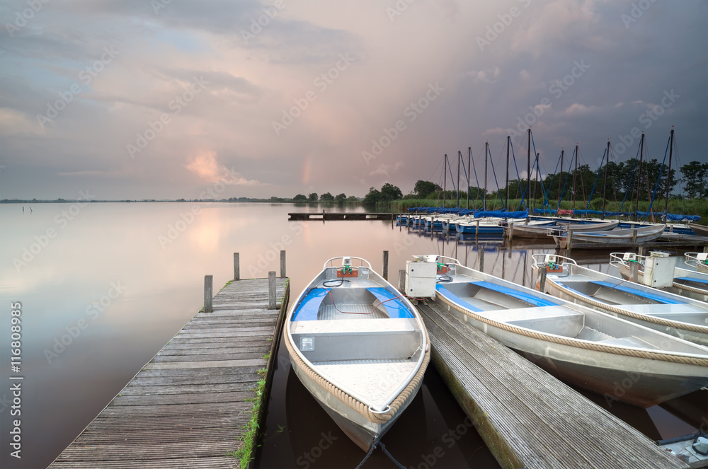 boats and yacht by pier on big lake