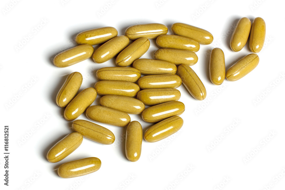 Collection of Mustard Colored Capsules on White Background Stock Photo