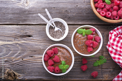 Chocolate Banana Smoothies served fresh juicy ripe raspberries with a sprig of mint in portioned bowls