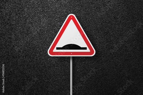 Road sign of the triangular shape on a background of asphalt. Artificial roughness. The texture of the tarmac, top view.