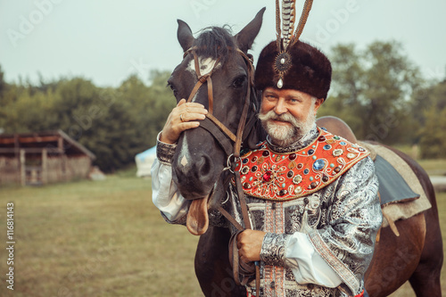 Vászonkép King dressed in medieval costume is stroking his horse