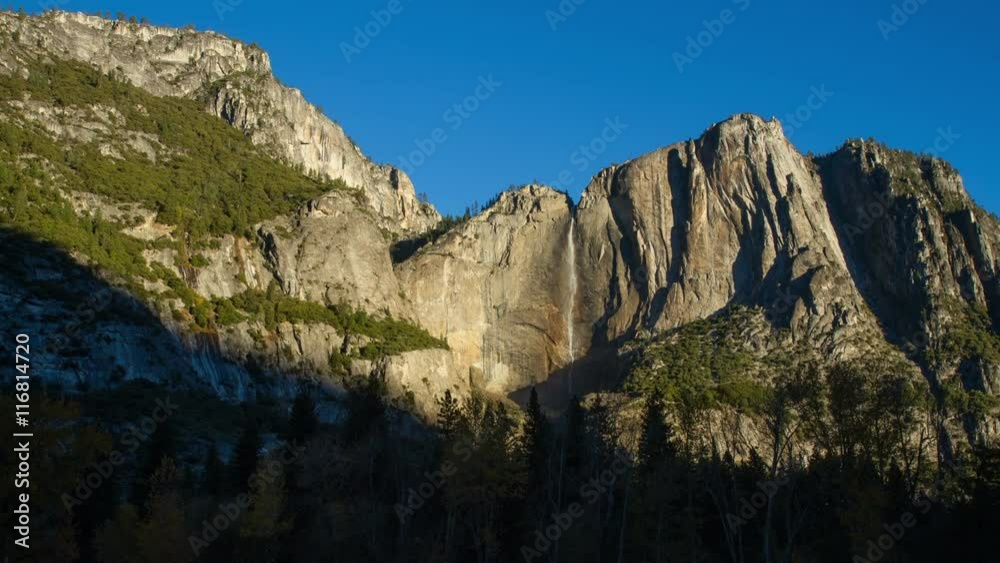 Time Lapse of of the beautiful cliffs and Yosemite Falls within Yosemite national Park. Shadows move across the cliff faces as the sun rises. Time Lapse of of the beautiful cliffs and Yosemite Falls within Yosemite national Park. Shadows move across the cliff faces as the sun rises.