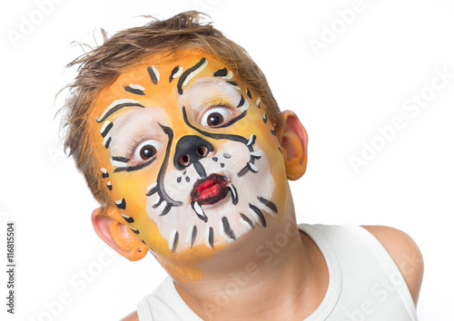 lovely adorable kid with paintings on his face as a tiger or lio