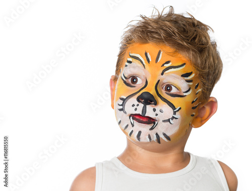 lovely adorable kid with paintings on his face as a tiger or lio