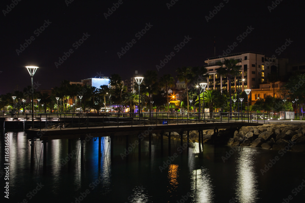 Night panorama from coast in Limassol, Cyprus island, Mediterranean Sea. Buildings with reflection in water surface
