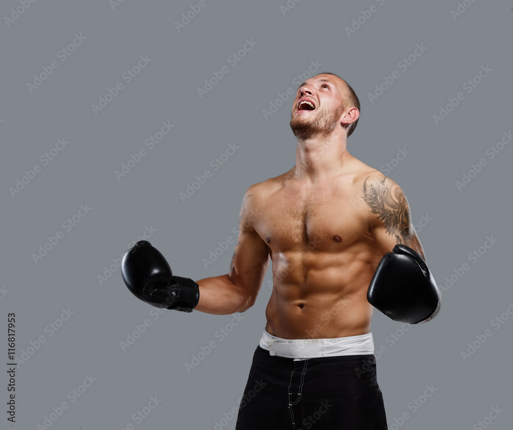 Tattooed fighter isolated on a grey background.