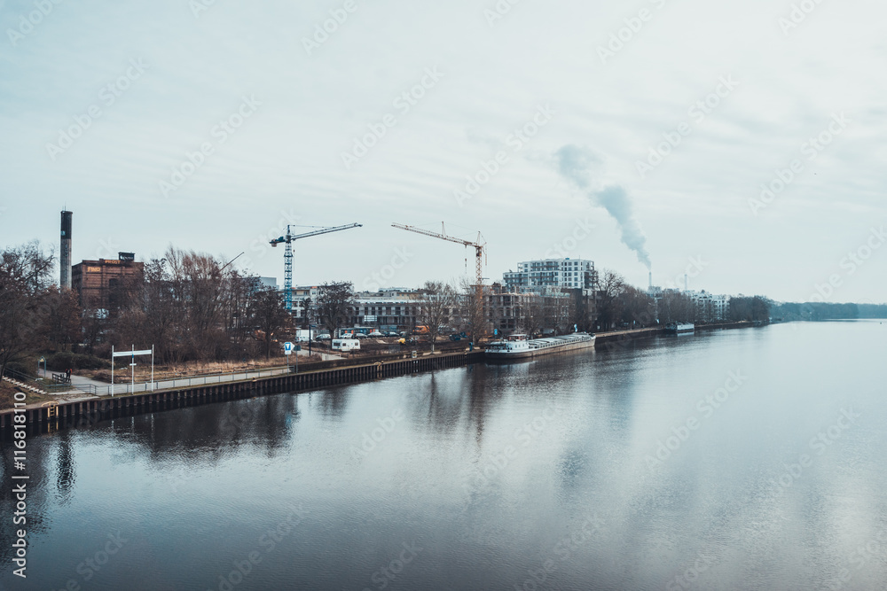 Obraz premium Two large cranes and smokestack