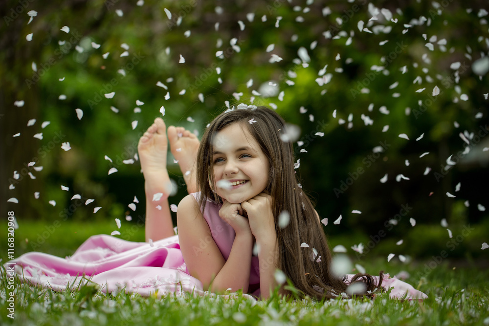 Little girl on green grass with petals Little girl on green grass with petals