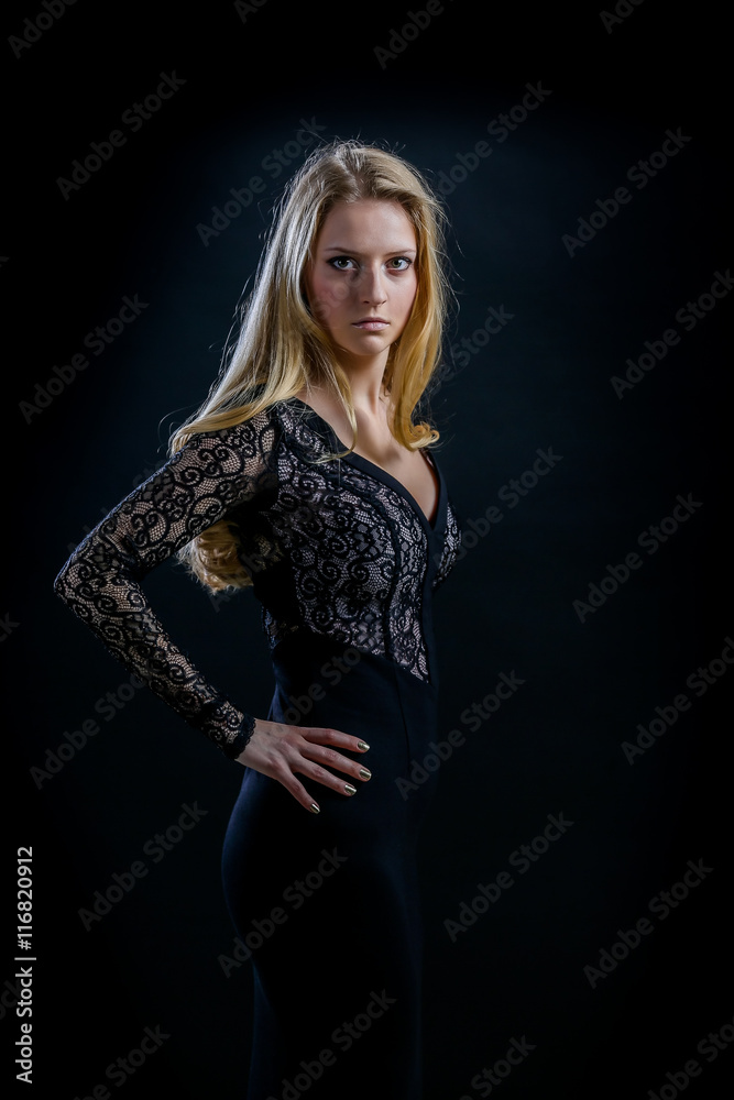 blonde girl on a black background in a dark guipure dress blonde girl on a black background in a dark guipure dress