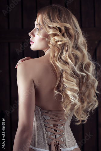 Fototapeta Sexy and sensual young woman in corset with long curls