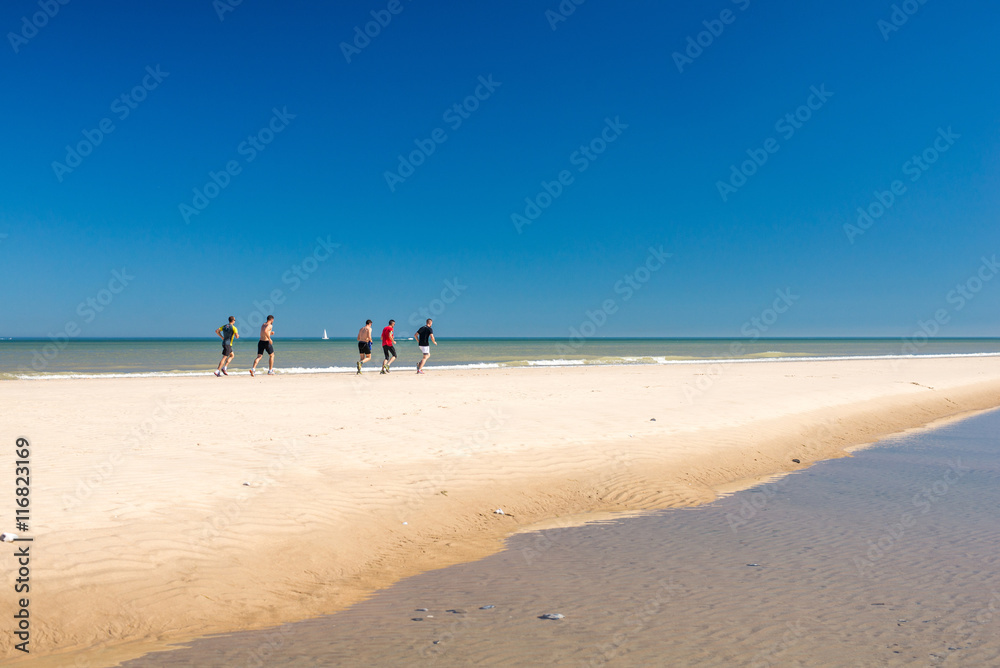 groupe d'homme courant sur la plage