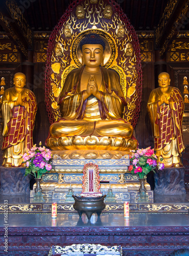 Golden Buddha statue sitting in lotus position
