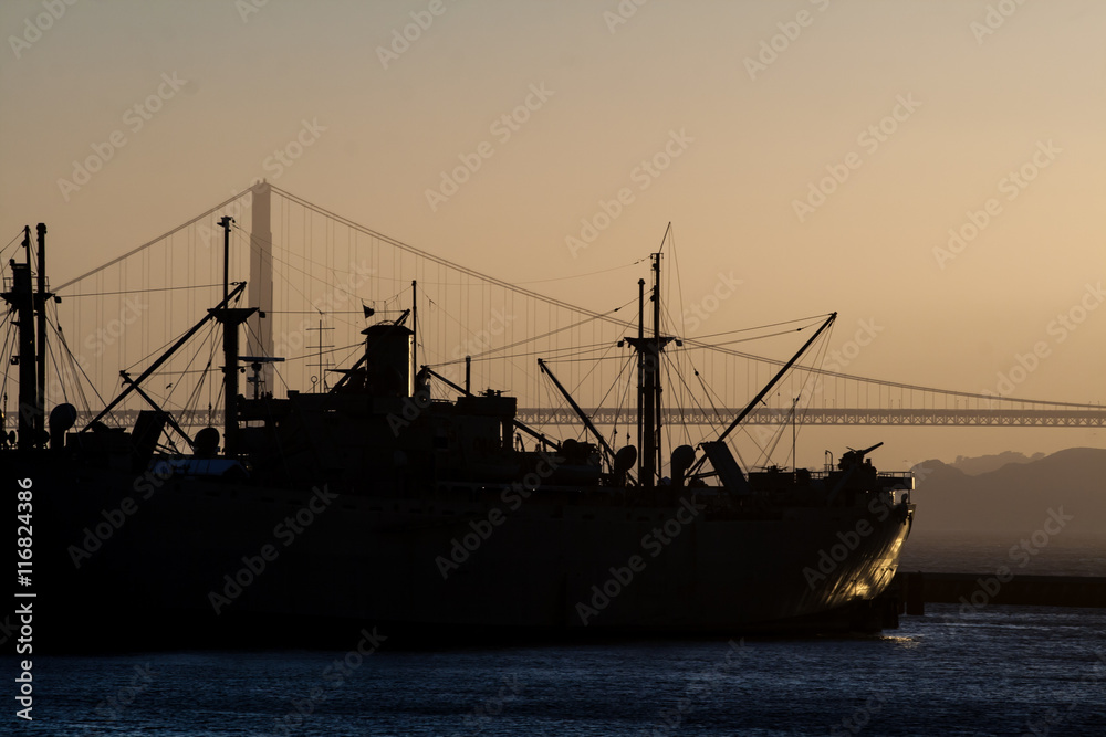 Fototapeta premium Silhouette of an old military ship during sunset