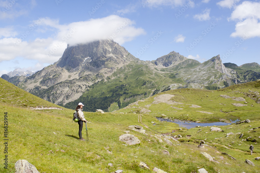 Naklejka premium woman in front of a lake in the middle of the mountains in France