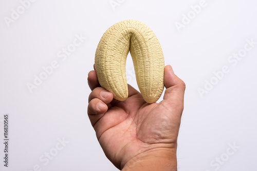Photography man's hand holding a banana like a big penis symbolizes lack of erection and imp