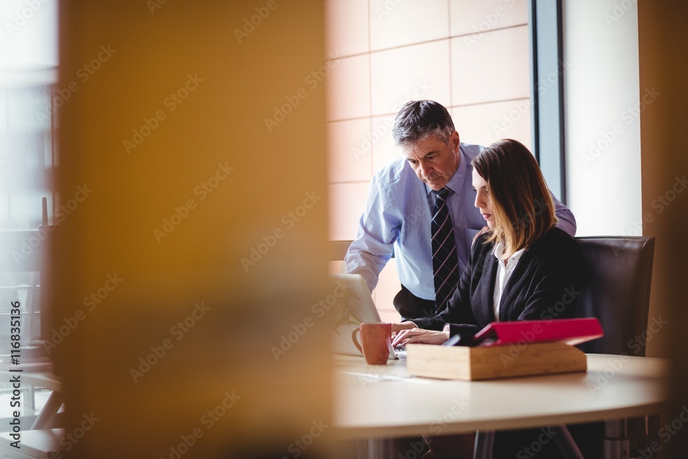 Businessman discussing with colleague over laptop Businessman discussing with colleague over laptop