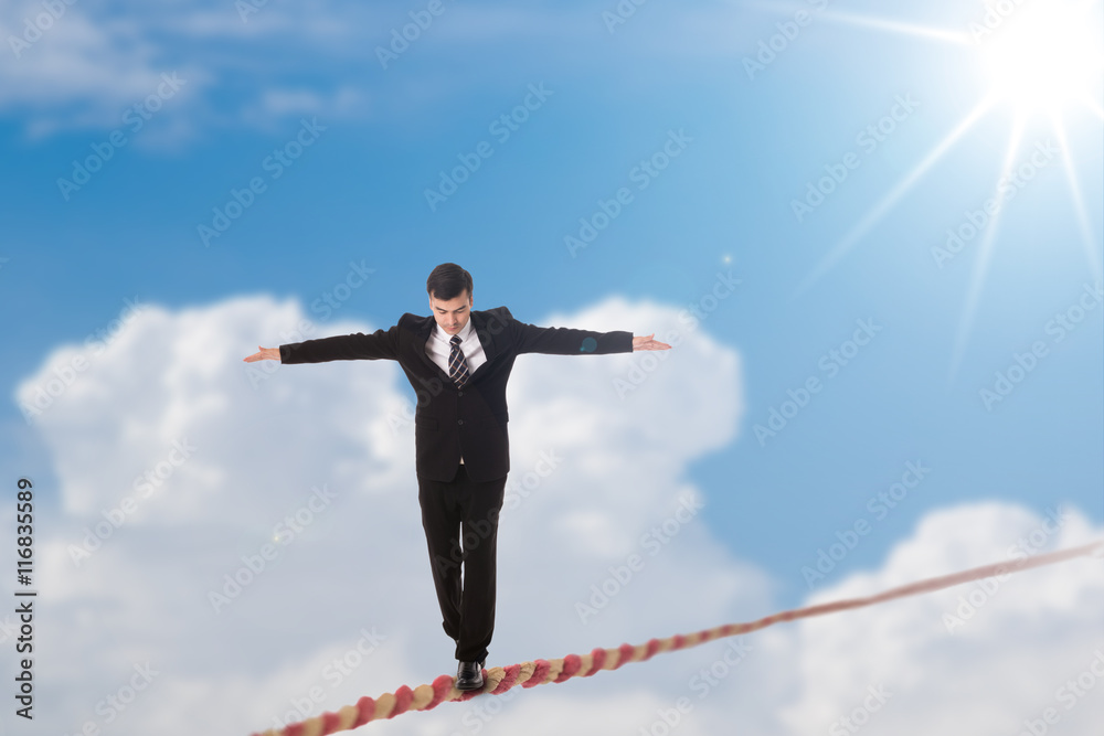 Business Risk management with man balancing on a rope concept Business Risk management with man balancing on a rope concept