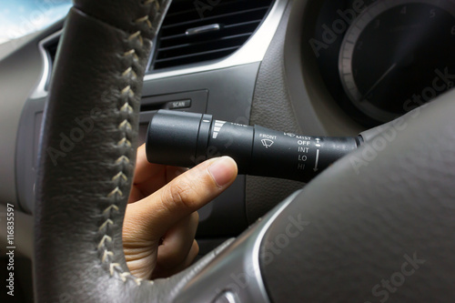 man hand use the signal switch. Car interior detail © oopoontongoo