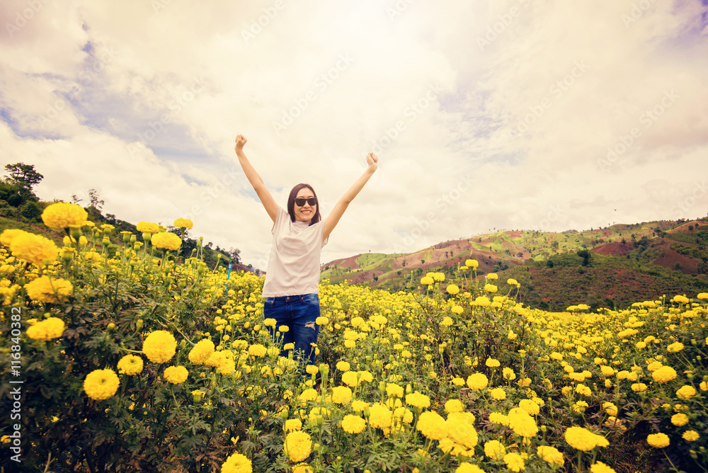 Beautiful Young Woman Outdoors. Enjoy Nature. show hand up with realxing in flower garden in front of the mountain. Vintage tone filter. Beautiful Young Woman Outdoors. Enjoy Nature. show hand up with realxing in flower garden in front of the mountain. Vintage tone filter.