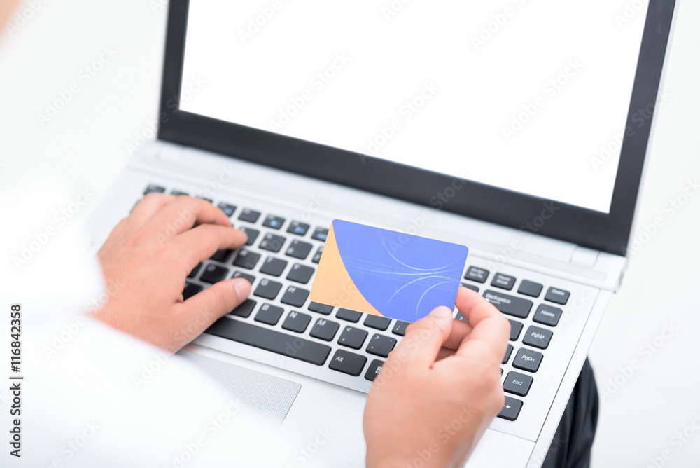 Man's hands holding credit card and using laptop for online payment. Man's hands holding credit card and using laptop for online payment.