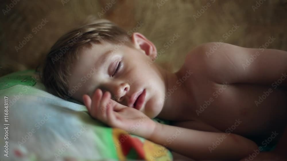 Little boy sleeping, in the dream his face muscles and body twitches