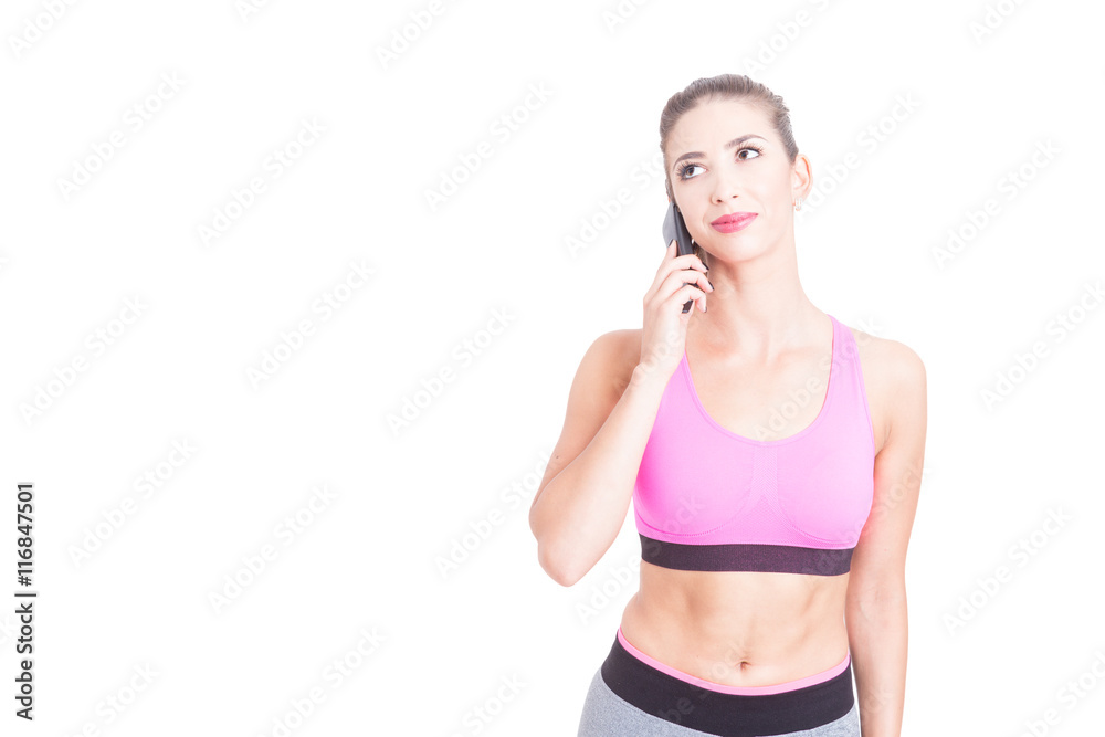 Fit girl speaking on telephone and looking up Fit girl speaking on telephone and looking up