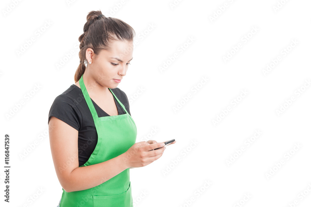 Attractive young seller typing a message on cellphone Attractive young seller typing a message on cellphone