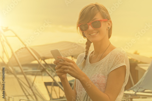 Girl using cellphone on a boat.