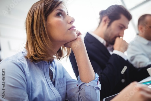 Thoughtful businesswoman with coworkers in meeting room