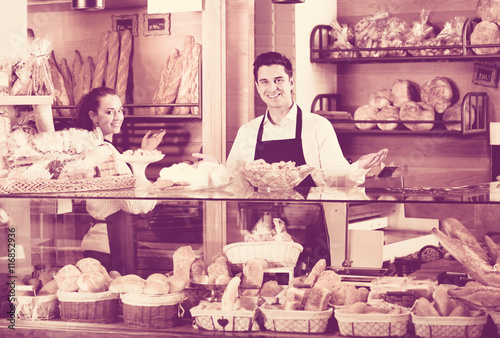 Portrait of friendly positive smiling couple at bakery display