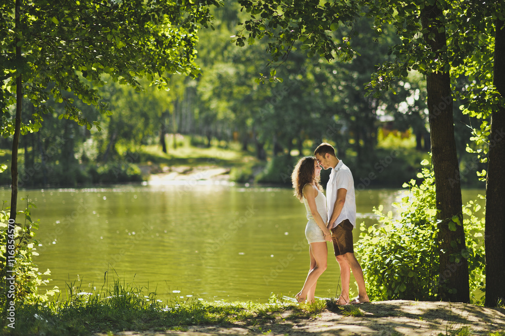 Fototapeta premium Young boy and girl standing on the shore of green lake 6302.