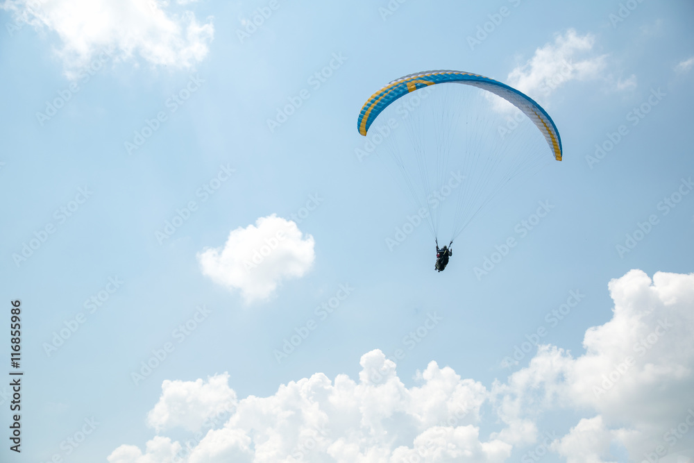 Paraglider in the blue sky, big blue clouds Paraglider in the blue sky, big blue clouds