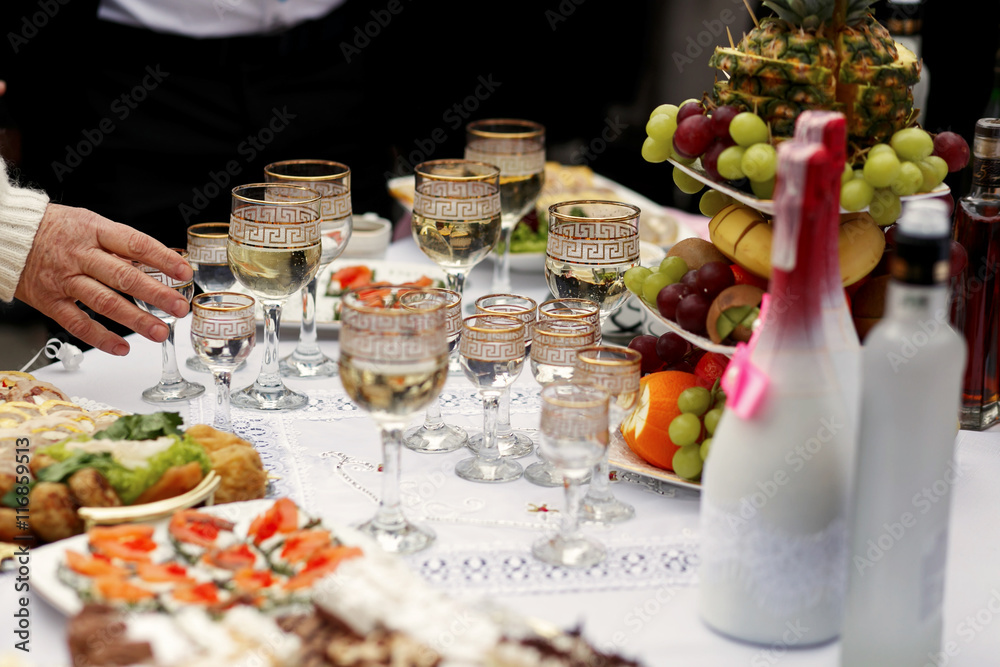 The buffet table with snacks and alcohol are near house The buffet table with snacks and alcohol are near house